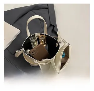 Vue intérieure du sac seau en cuir ciré crème montrant une grande capacité