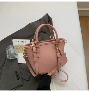 Pink lychee grain leather bucket bag with bear charm and adjustable shoulder strap