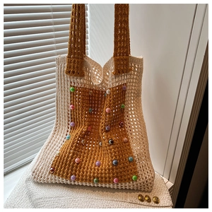 Detail of hand-knitted tote bag with colorful beads and striped patchwork design