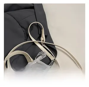 Détail du sac seau crème montrant la bandoulière réglable et les breloques perles