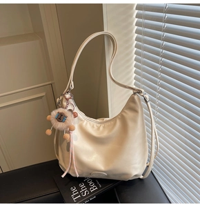 Dettaglio della borsa hobo in PU bianco crema con un simpatico ciondolo a pecora sulla zip
