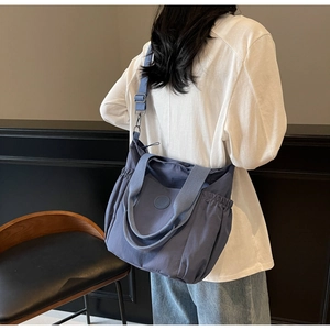 Detail of blue canvas tote bag with side drawstring pocket and adjustable shoulder strap
