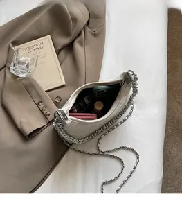 Details des geräumigen Innenraums der weißen Stepptasche mit silberner Gliederkette