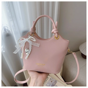 Detailaufnahme der rosa Beuteltasche mit Knotengriff und Perlenspitzen-Schleifenanhänger