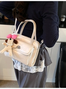 Cream white glossy faux leather handbag with dog plush charm and silver twist lock