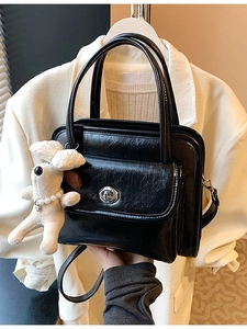 Chic black PU leather handbag with silver rotary buckle and plush dog charm accessory