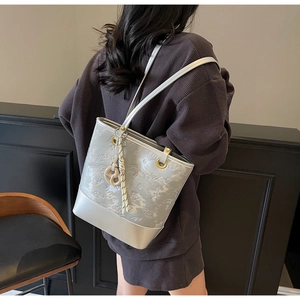 Borsa a secchiello grigio argento goffrata con lettere SNML e motivo a farfalla su modella