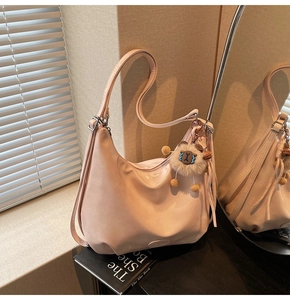 Dettaglio della borsa hobo rosa chiaro con ciondolo a pecora e logo sul fondo