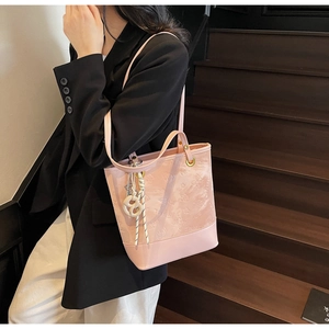 Dettaglio della borsa rosa goffrata con motivi a farfalla e ciondolo decorativo in corda