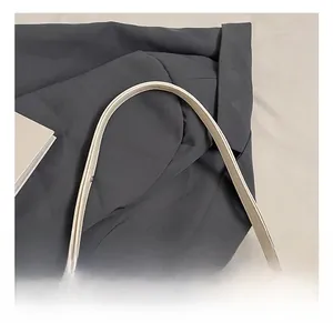 Gros plan d'une bandoulière en cuir crème avec bordure huilée et boucle en métal réglable