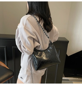 Schwarze gesteppte Hobo-Tasche mit Silberkette als Teil eines lässigen schicken Outfits