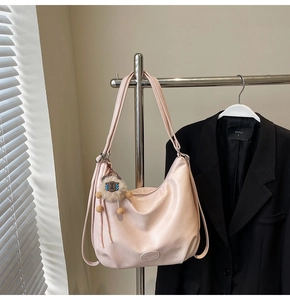Dettaglio della borsa tote rosa chiaro a mezzaluna con ciondolo in peluche e pelle PU