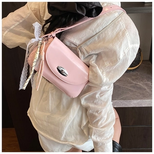 Détail du sac bandoulière rose en cuir PU avec nœud en dentelle et fermoir rotatif
