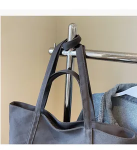Detail of sturdy double handles on the large dark grey canvas tote bag for daily commute
