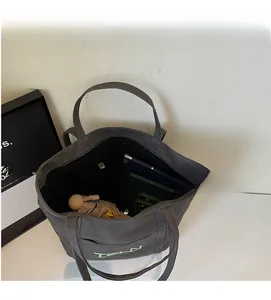 Interior view showing the large capacity and storage compartments of the canvas tote bag