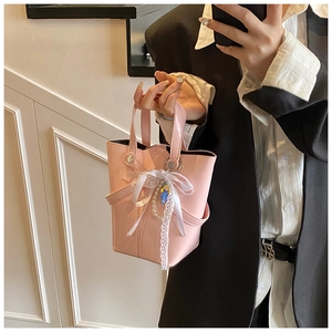Sac seau rose avec dentelle blanche, nœud et breloque en perles en selfie miroir