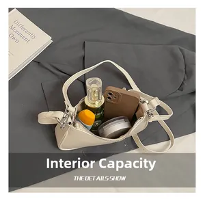 Vista detallada que muestra la gran capacidad interna del bolso beige con objetos diarios