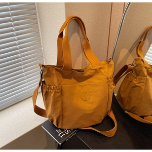Detail of amber yellow multi-pocket tote bag showing texture and adjustable strap