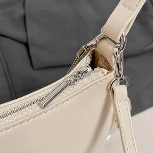 Primer plano de herrajes plateados y detalle de correa de cuero beige suave
