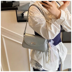 Sac sous le bras bleu clair avec fermoir rotatif argenté et breloque en dentelle