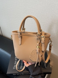 Caramel brown pebbled leather bucket bag with top handles and logo gold hardware