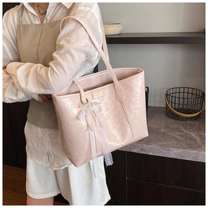Close-up of pink embossed tote bag featuring cute cartoon animals and lace pearl bow charm