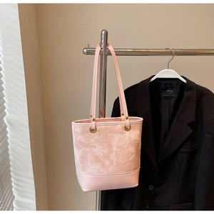 Dettaglio della borsa tote rosa con farfalle a rilievo e texture con scritta SNML