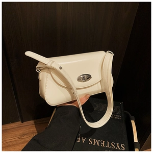 Gros plan du sac sous le bras crème avec fermoir rotatif ovale en métal et texture cuir lisse