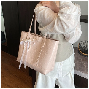 Detail of light pink embossed tote bag with floral puppy patterns and lace bow accessory