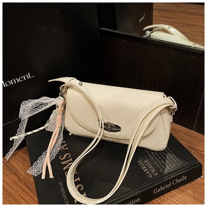 Détail du sac crème avec fermoir corne argenté et charmant nœud en dentelle blanche
