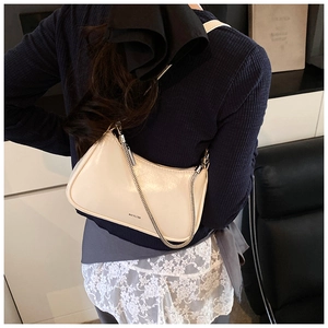 Detalle del bolso de hombro en charol blanco crema con estampado NO FILTER y cadena de plata