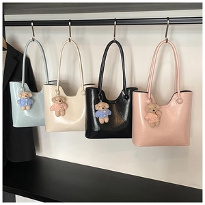 Detailed view of fashionable tote bags in four colors featuring cute teddy bear charms