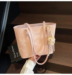 Pink marble pattern tote bag with teddy bear charm shown on a rustic wooden staircase