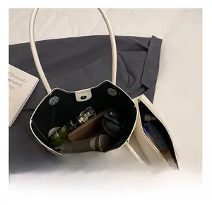 Top view of spacious cream leather tote bag interior with inner pouch and daily essentials
