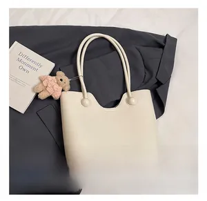 Creamy bucket bag detail featuring a wavy top edge and cute teddy bear charm