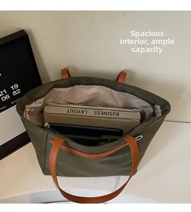 Detailed top view of a spacious green oxford tote interior holding a laptop and books