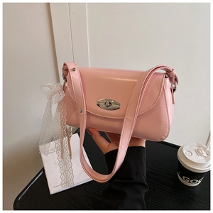 Détail du sac sous le bras rose avec fermoir rotatif argenté et ruban de dentelle