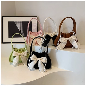 Detail of colorful corduroy bow handbags in pink, white, brown, green and black colors