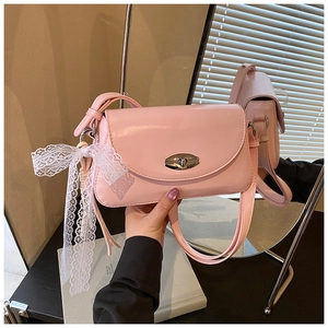 Gros plan du sac sous le bras rose avec fermoir argenté et nœud en dentelle blanche