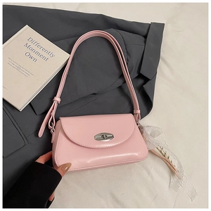 Détail du sac sous l'aisselle en similicuir rose avec fermoir rotatif et ruban de dentelle