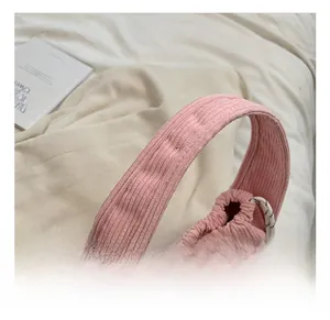 Detailed view of pink corduroy handbag with soft handles and white decorative bow
