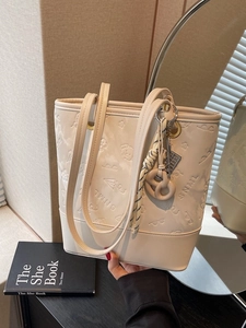 Elegante borsa tote bianco crema con motivi SNML a rilievo e ciondolo intrecciato