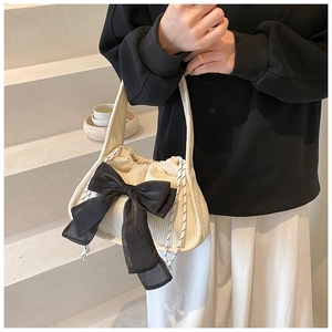 Détail du sac bandoulière en velours côtelé crème avec grand nœud noir et cordon
