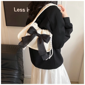 Détail du sac à bandoulière en velours blanc avec nœud noir et bandoulière en corde