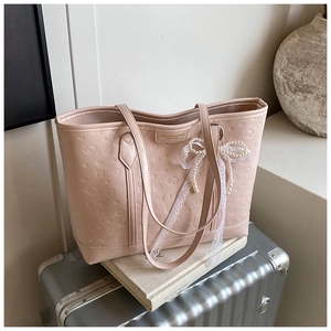 Detail of pink PU leather tote featuring cartoon dog embossing and pearl bow charm