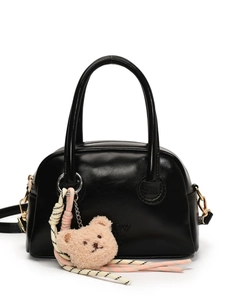 Sac à main en cuir noir brillant avec breloque ours en peluche et sangle tissée, vue de face