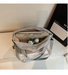 Vue du dessus du sac cabas gris spacieux contenant ordinateur portable, livres et objets