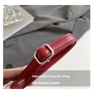 Macro detail of red leather adjustable shoulder strap with silver metal square buckle