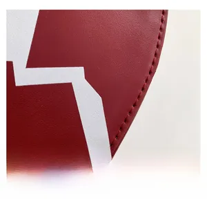 Close-up of red leather texture with white geometric print and precise stitching details
