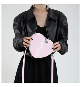 Detail of pink heart-shaped handbag with white lightning motif and silver hardware